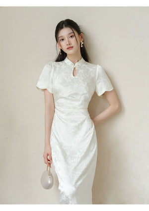 Soft White jacquard pleated qipao dress styled to show its fit and drape, including subtle jacquard, fitted waist, front pleats and keyhole mandarin collar.