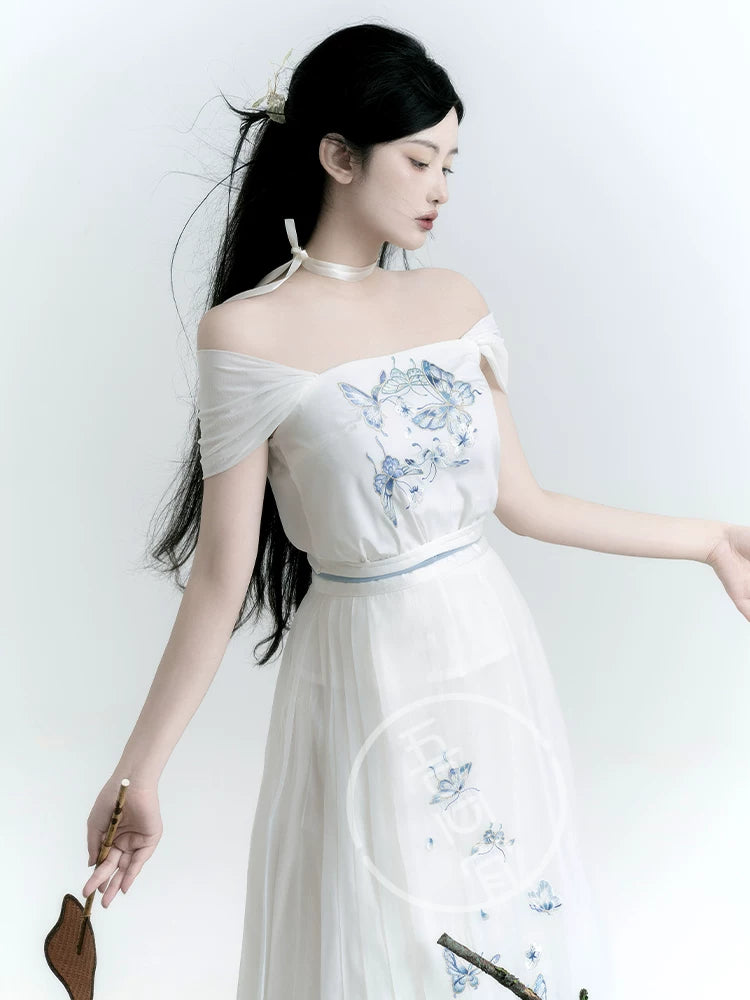 White butterfly Hanfu camisole with blue embroidery, shown with its wide straps draped off the shoulders
