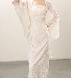 Detailed product image of the White embroidered slip dress and sheer outer layer, showing fabric texture, finish and craftsmanship.