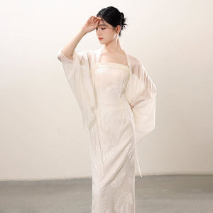 Additional styling view of the White embroidered slip dress and sheer outer layer, showing the garment's shape, texture and finish.