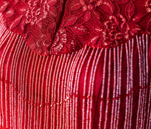 Close-up of red floral lace and beaded tassels