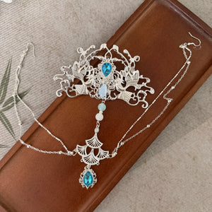 Silver-tone crown with blue accents laid flat