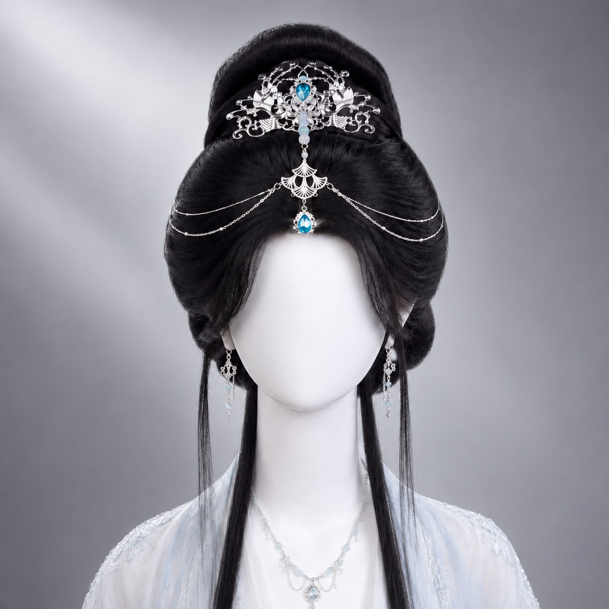 Silver-tone forehead crown with blue teardrop accent styled on an updo