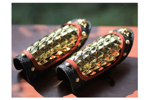Gold dragon-scale forearm guards with brass dragon-head ornaments and cotton cord lacing