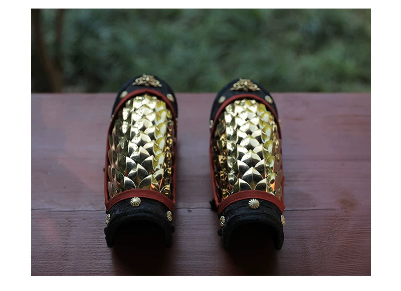 Close-up of gold scale armor panel fitted along the forearm with adjustable side lacing
