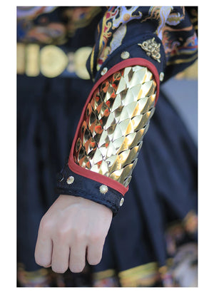 Gold stainless steel overlapping scales reflecting light on a tapered forearm guard