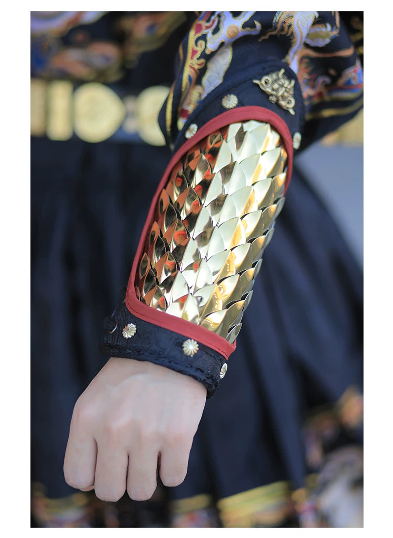 Gold stainless steel overlapping scales reflecting light on a tapered forearm guard