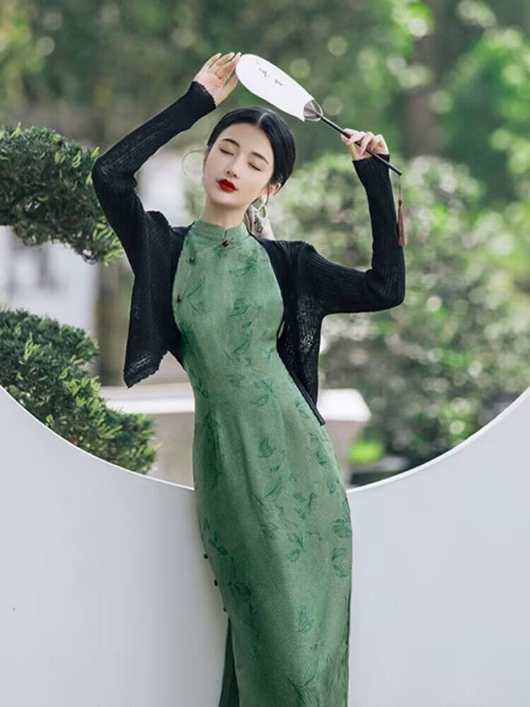 A green silk Cheongsam featuring puff sleeves, perfect for modern weddings and formal occasions. This custom-made, cosplay-friendly Cheongsam, available in plus sizes, merges tradition with modern cheongsam patterns and design elements such as short dress style and dress slits. Styled with a modern Cheongsam top, it is the epitome of contemporary fashion. Sold in USA and worldwide