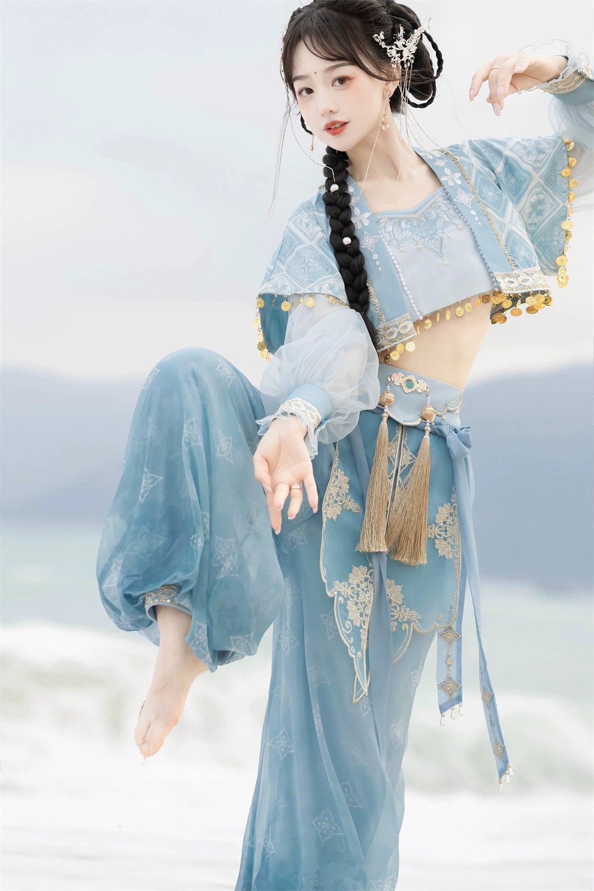 Dynamic pose in blue Hanfu Princess Jasmine suit by 【Cloud Traveler】, highlighting ethnic design and sheer fabric on the beach.
