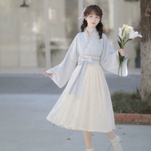 Model wearing Blue Modern Hanfu Dress with floral lace skirt and ribbon belt, styled for spring elegance and daily wear.