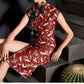 Model seated in red cheongsam with crane print and stylish split skirt.