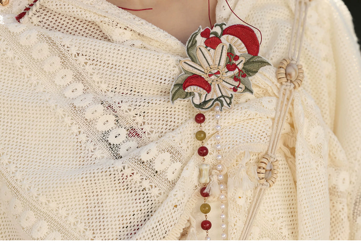Lace shawl edge and red green decorative motif closeup