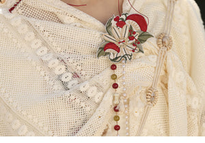 Lace shawl edge and red green decorative motif closeup