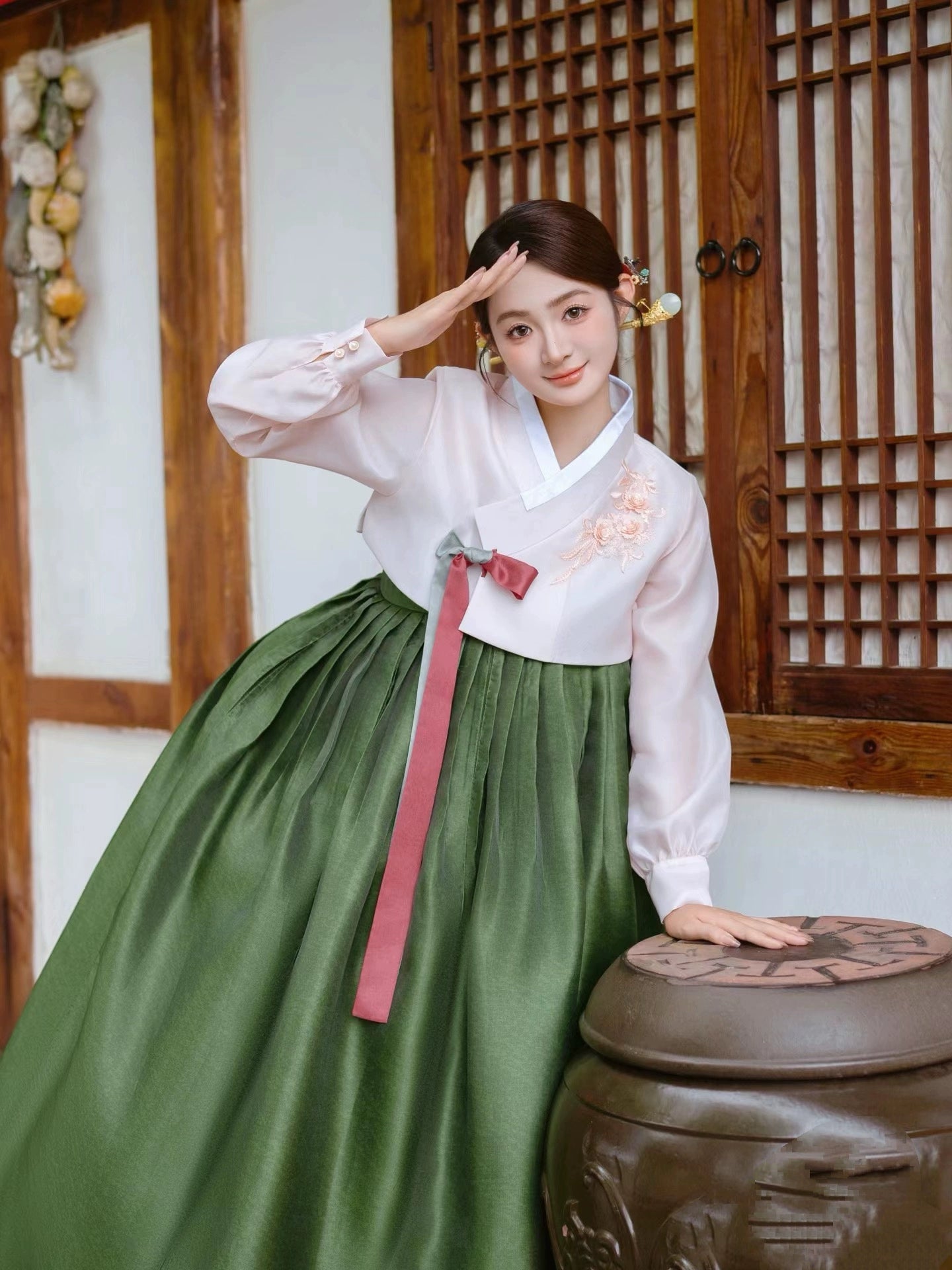 Traditional green hanbok with white top, worn in a cultural setting.