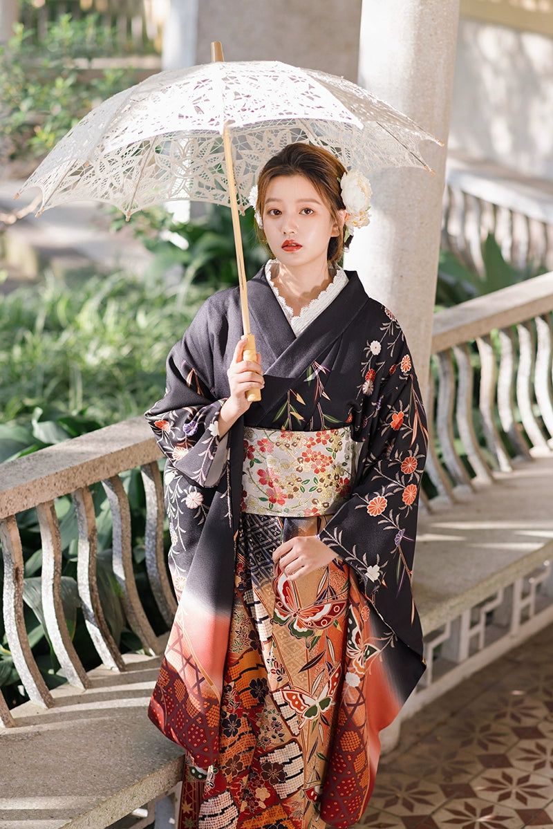 Traditional black kimono with butterfly motifs, styled with a lace parasol.