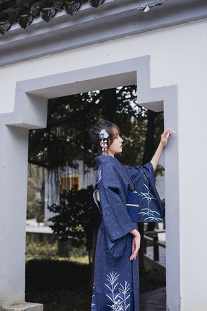 Back view of blue Japanese kimono yukata with floral patterns and obi belt.