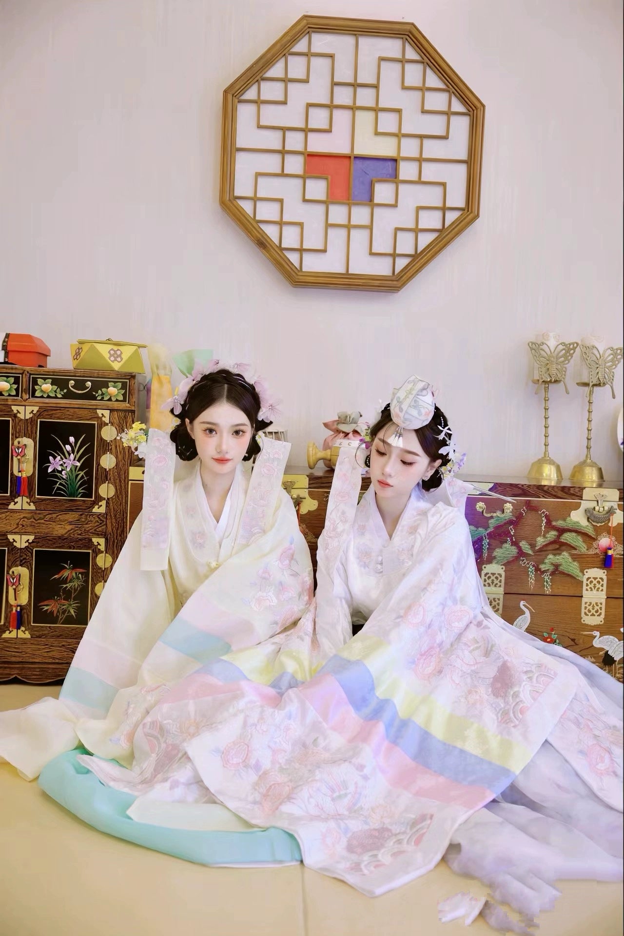 Elegant duo in Muzhi Korean embroidered wedding dresses, featuring intricate floral embroidery and pastel hues for a traditional bridal look.