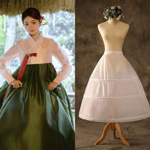 Green hanbok paired with a white petticoat, showcasing traditional attire details.