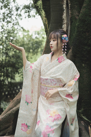 White kimono with floral prints, styled with a pastel obi, worn in a tranquil forest.