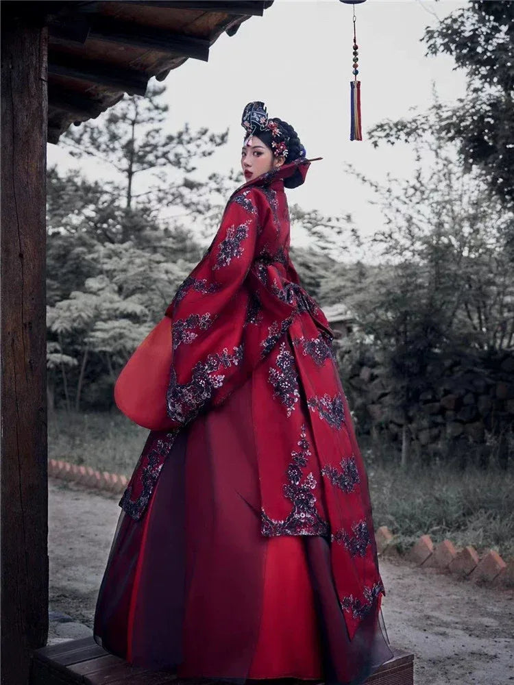 korean red wedding dress A photo of a Korean actress wearing a vibrant red embroidered ball-gown-style wedding dress with sparkling sequins and beads creating a floral pattern. The dress has a v-neckline, long sleeves with slight