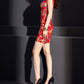 Side profile of red cheongsam dress with dragon print and gold bracelet.