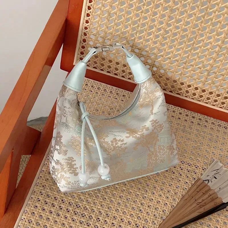 Chinese style silk embroidery handbag photographed as a refined qipao accessory.