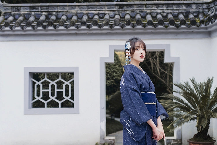 Blue Japanese kimono yukata styled in a serene outdoor setting.