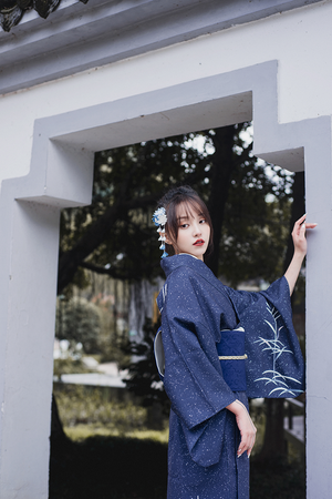 Close-up of blue Japanese kimono yukata with floral details and obi belt.