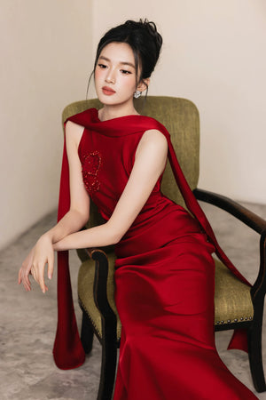 Seated front view of red hand-beaded formal evening gown