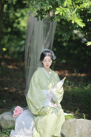 Avocado green kimono dress with lace parasol and floral accents.