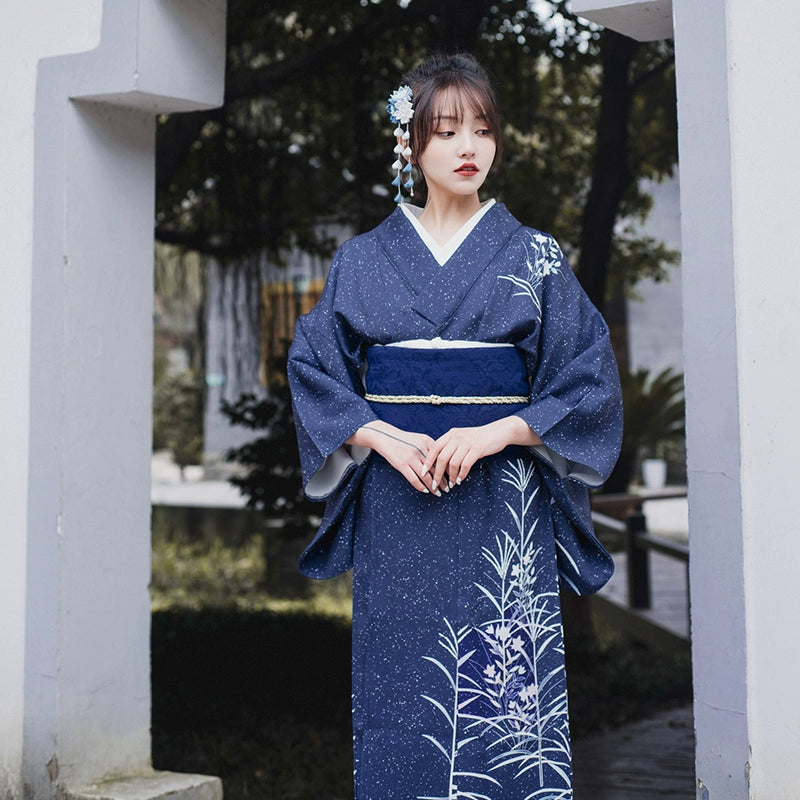 Blue Japanese kimono yukata with intricate floral details, styled with obi belt.