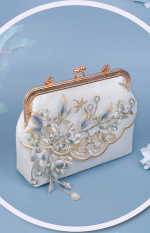 Close-up of Yuejian white embroidered Hanfu bag with gold floral details and ornate clasp, showcasing its intricate craftsmanship.