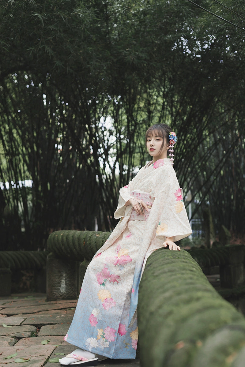 White floral kimono with pink and yellow accents, styled with a matching pastel obi.