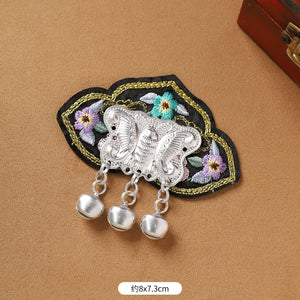 Guizhou Miao fridge magnet with black floral embroidery and silver butterfly fringe, 8x7.3cm, handmade cultural decor.