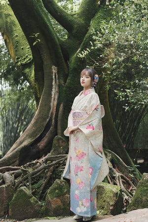 Full-length view of a white floral kimono with blue accents, worn in a natural setting.