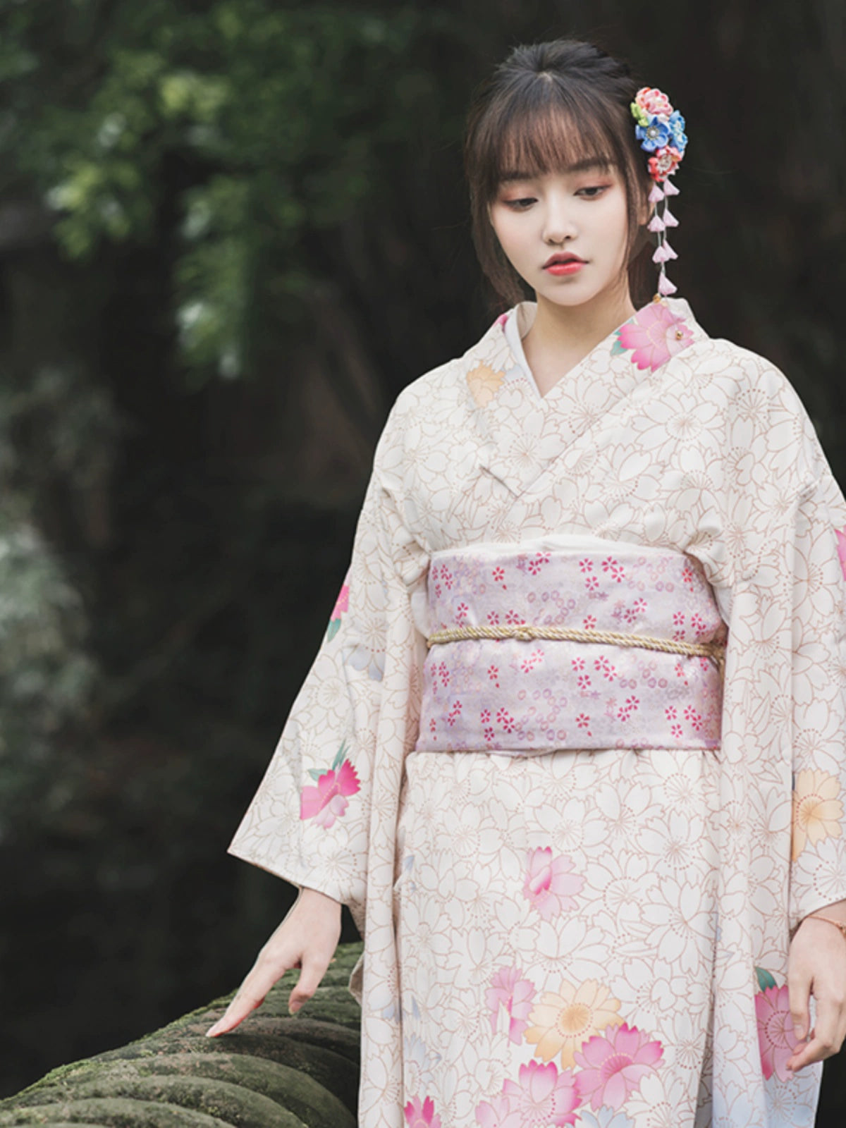 Close-up of a white Japanese kimono with intricate floral patterns and a pastel obi.