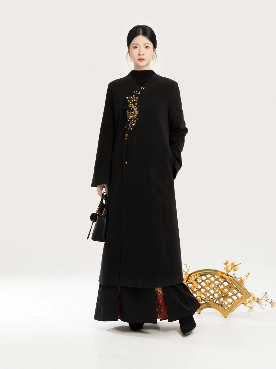 Black coat with black sweater and long pleated skirt