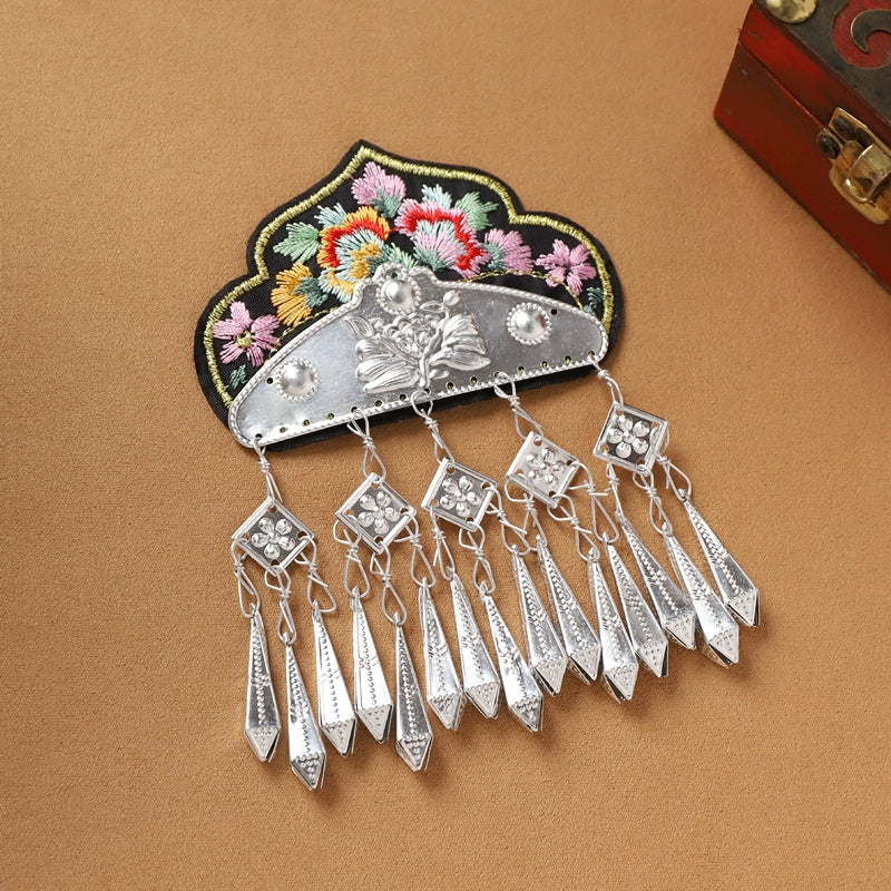 Black embroidered Guizhou Miao fridge magnet with silver diamond-shaped fringe, handmade ethnic kitchen ornament.