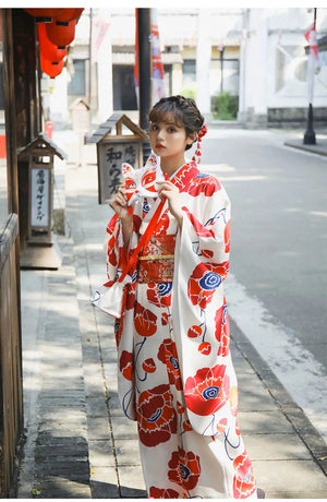 Close-up of the white fabric with red floral patterns from the Japanese kimono dress, highlighting the intricate artistic design.