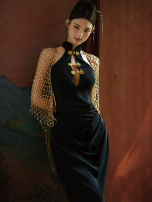 Elegant black fishtail cheongsam dress with gold floral accents and a sheer beaded shawl, styled for formal occasions.