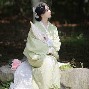 Retro-style avocado green kimono dress with delicate lace parasol.