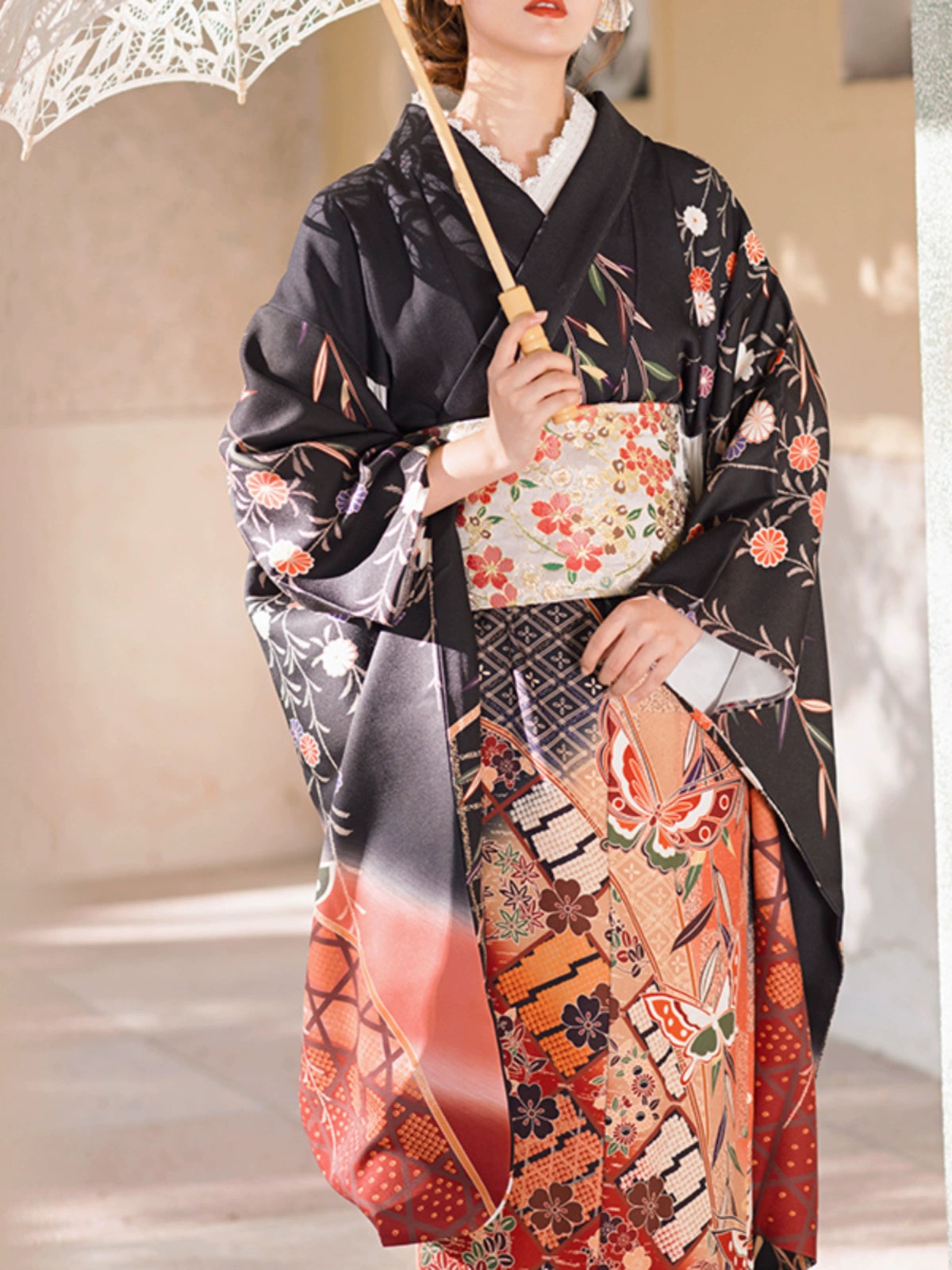 Detailed view of a black kimono with vibrant butterfly and floral patterns.