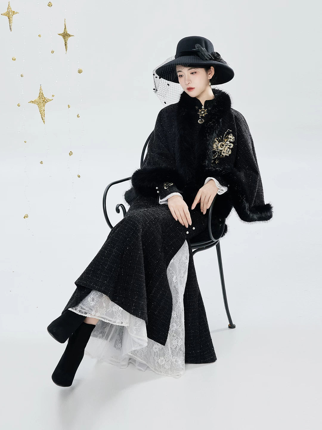Black qipao and cape seated view with skirt detail