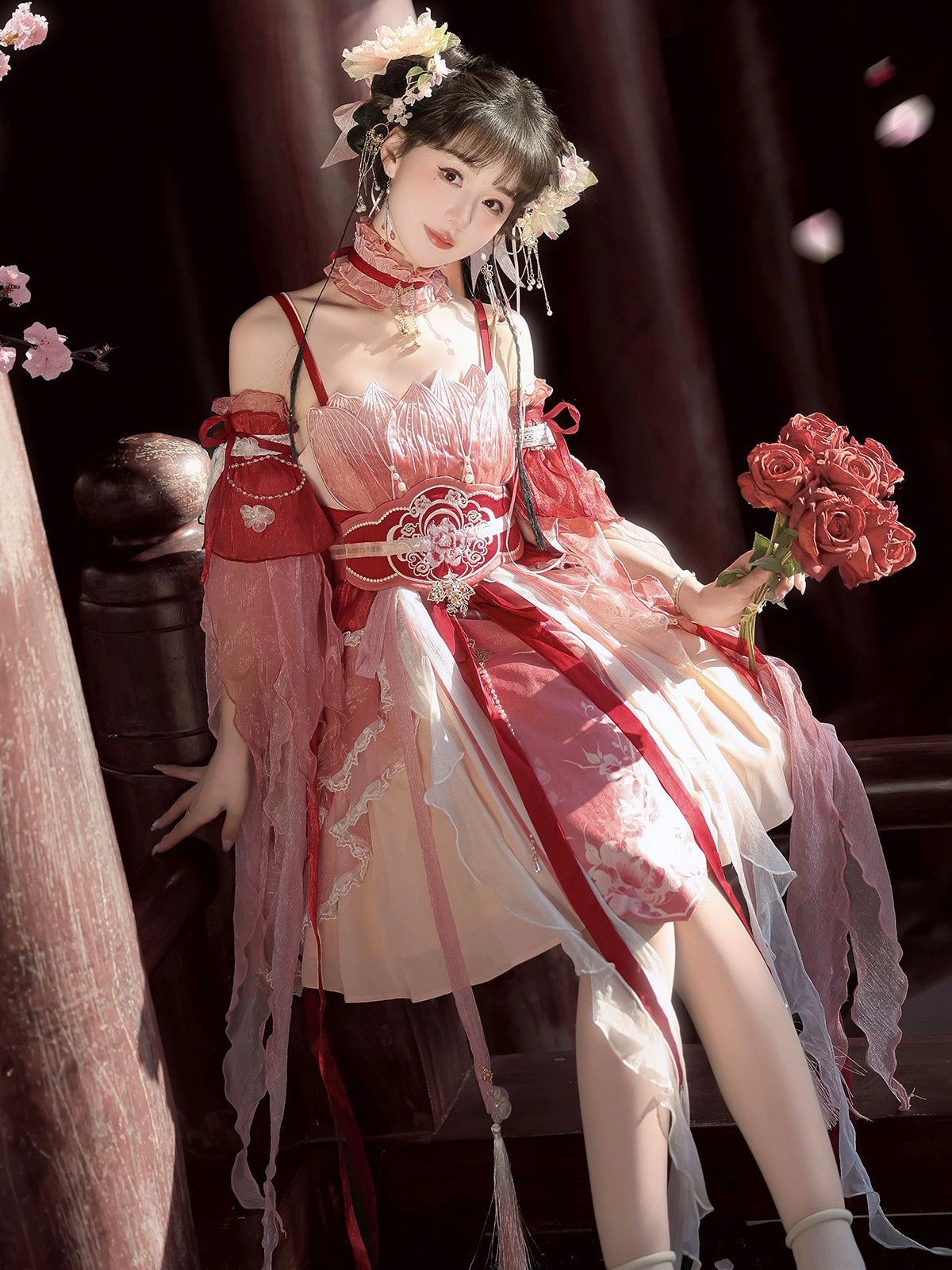 Seated model in Red Hanfu Dress New Chinese Feather Rust Waist Seal Suspender Skirt holding roses, highlighting layered skirt and waist seal.