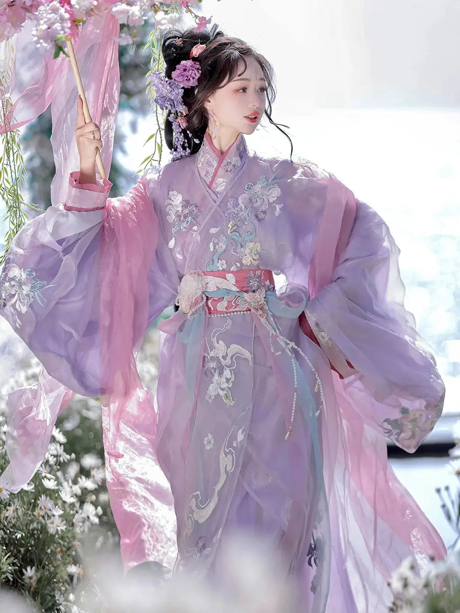 Woman in purple Hanfu holding flowers in a garden