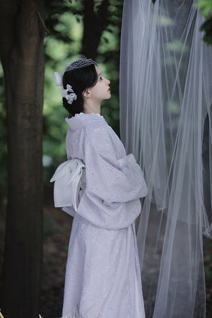 Back view of a purple lace kimono with a white obi in a forest.