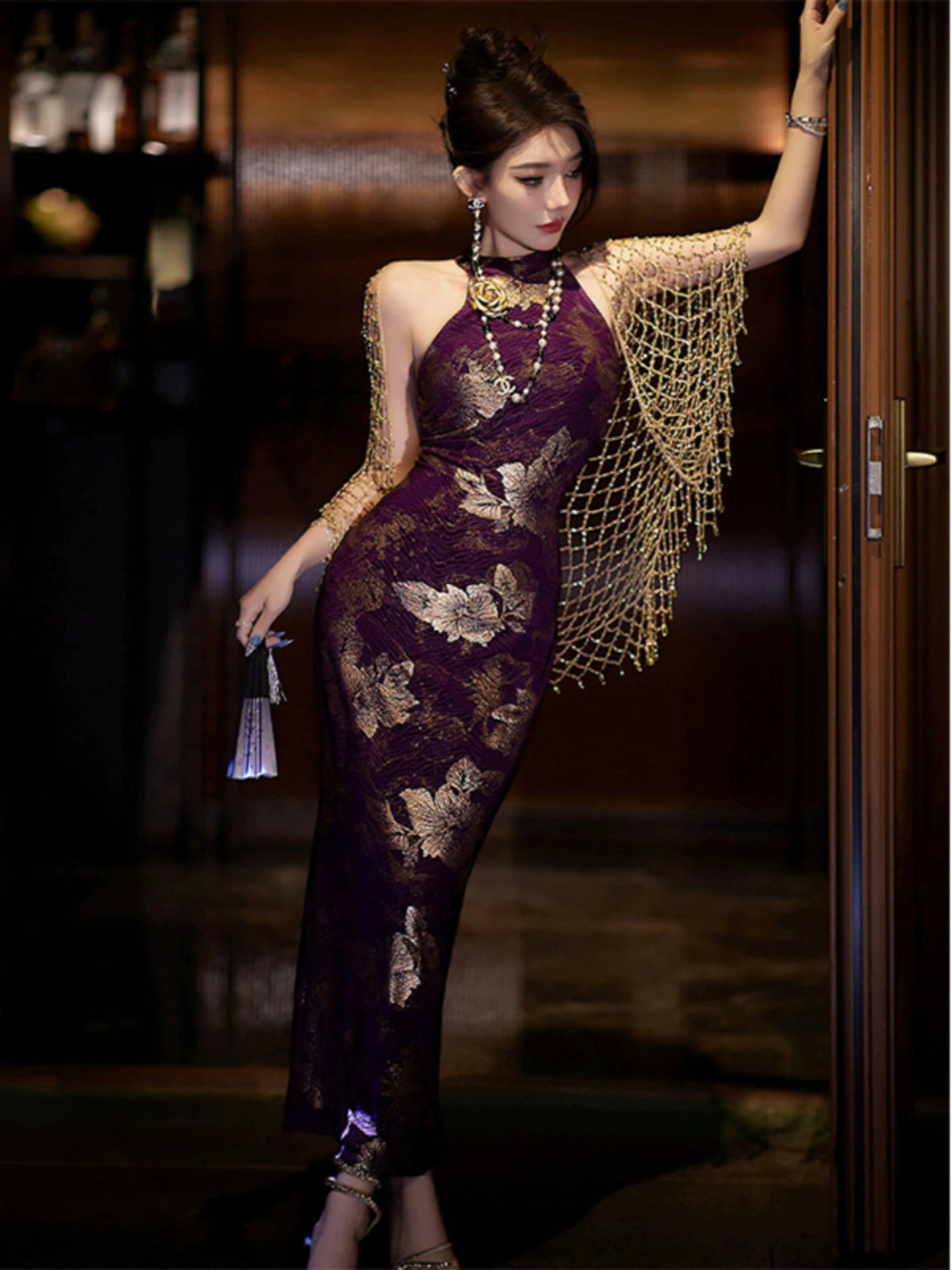 Elegant purple jacquard cheongsam dress with gold floral patterns, halter neckline, and gold shawl, perfect for evening wear.