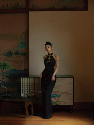 Elegant black fishtail cheongsam dress styled in a traditional setting with gold accents and a beaded shawl.