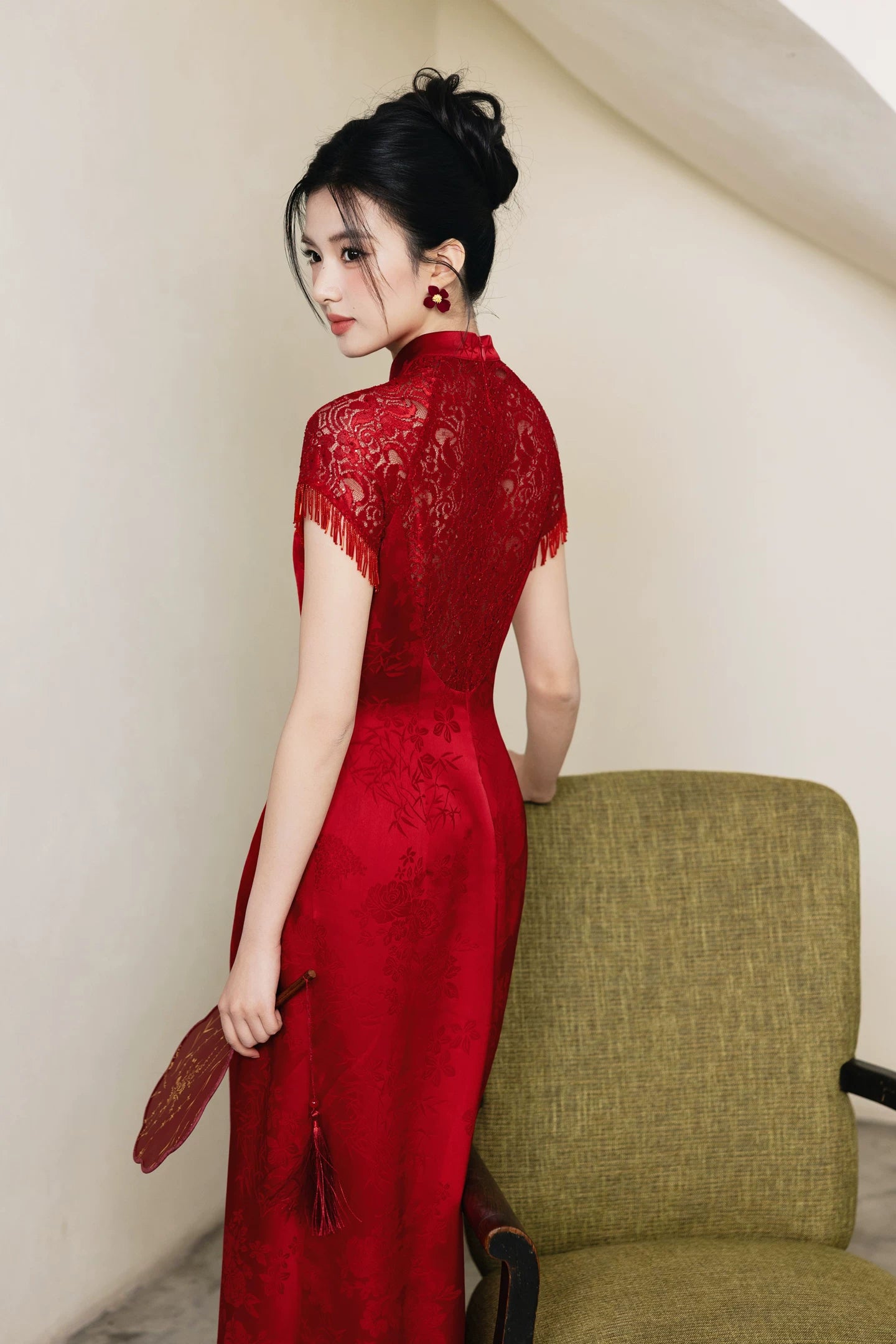 Back three-quarter view showing lace shoulders on red bridal cheongsam
