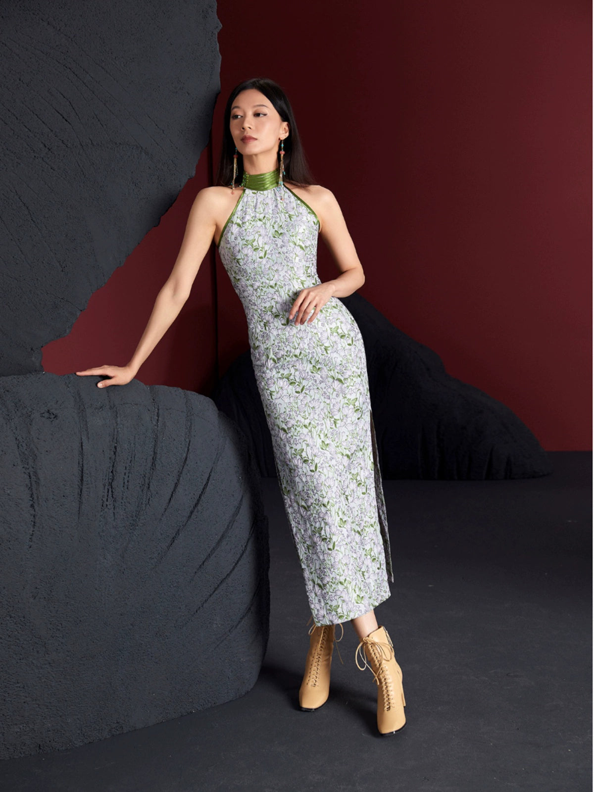 Long sleeveless cheongsam dress with a green floral jacquard pattern, high slit, and fitted silhouette. Made from cotton, silk, and polyester.